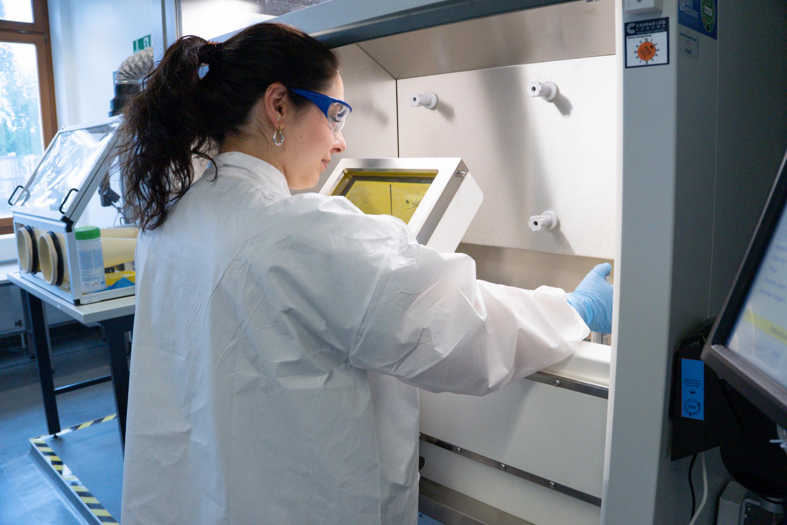 Scientist working with radioactive material inside an isotope hood.